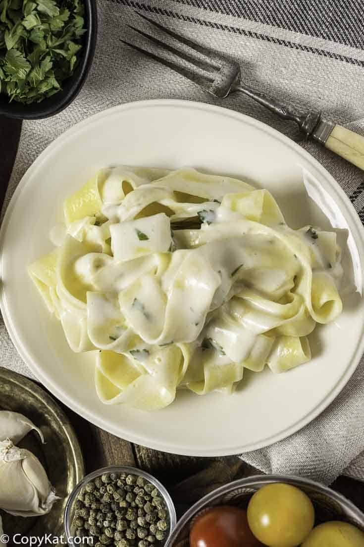 Alfredo sauce over pasta on a plate.