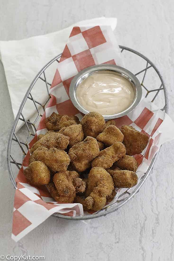 chicken nuggets and dipping sauce in a wire basket