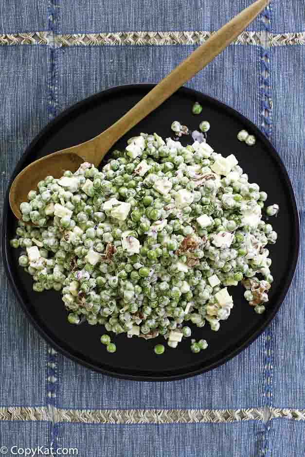 A plate of pea salad with bacon and cheese