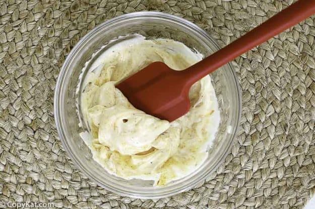 stirring in seasonings to dressing for pea salad