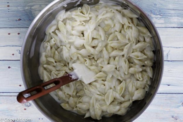 Stirring Panera Bread Macaroni and Cheese in a stainless steel prep bowl.
