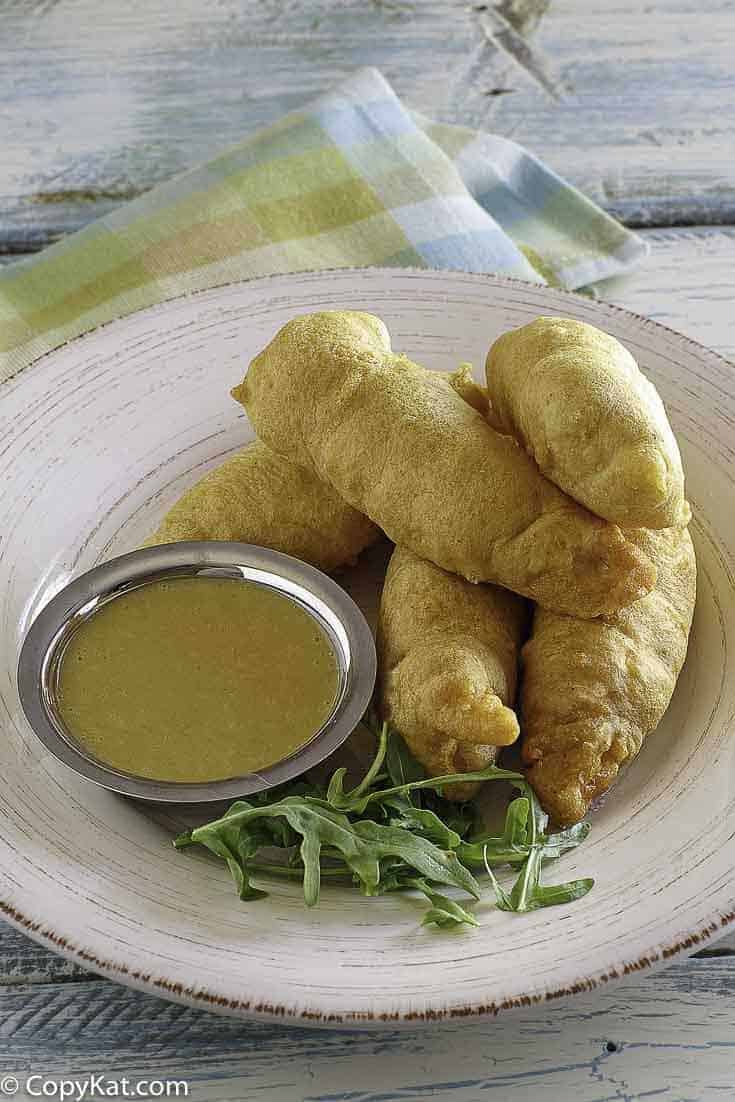 Copycat Chili's Chicken Crispers and honey mustard sauce on a white plate.