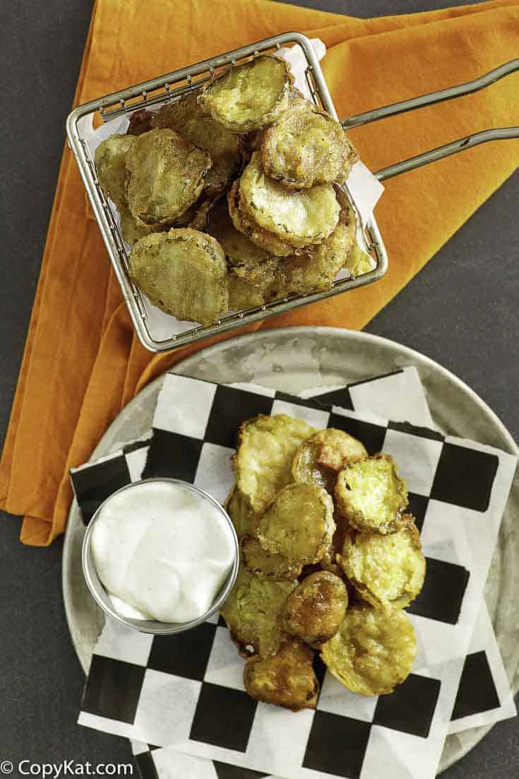 fried pickles in a fry basket and on a plate