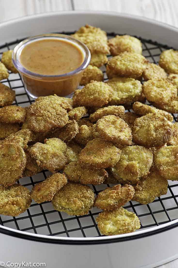 Homemade copycat Red Robin Pickle Nickels (fried pickles) and dipping sauce on a serving platter.