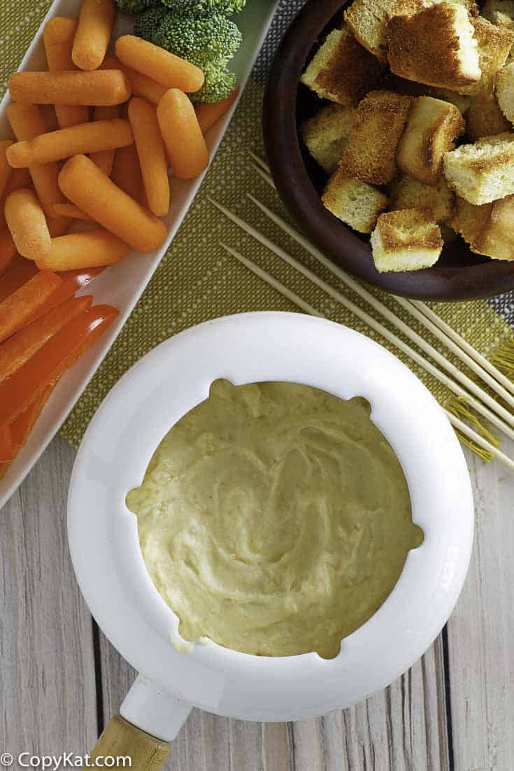 Homemade Melting Pot Traditional Swiss Fondue with vegetables and bread cubes.
