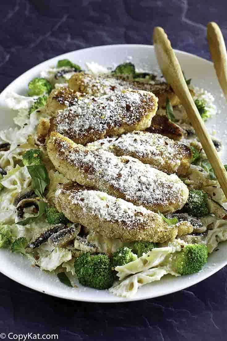 Parmesan crusted chicken tenders and pasta on a plate.