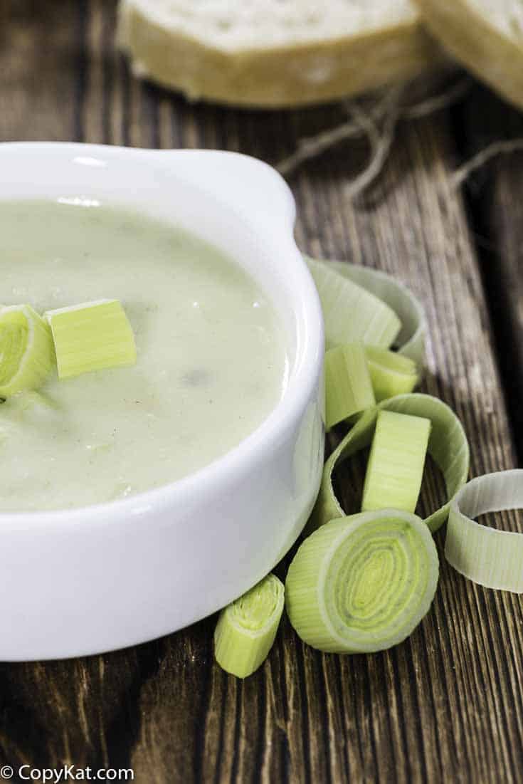 a bowl of potato leek soup with a few cut up leeks
