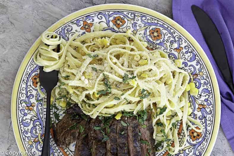 Fettuccine and corn salad served with a grilled steak
