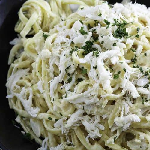 A plate of alfredo pasta with crab