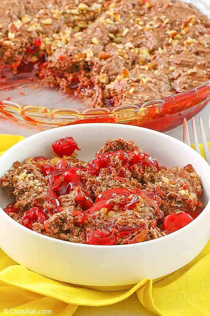 a bowl of cherry chocolate cobbler in front of the cobbler