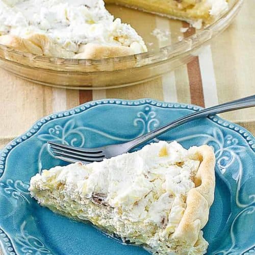 Homemade Furr's Pineapple Millionaire Pie on a blue plate next to the pie
