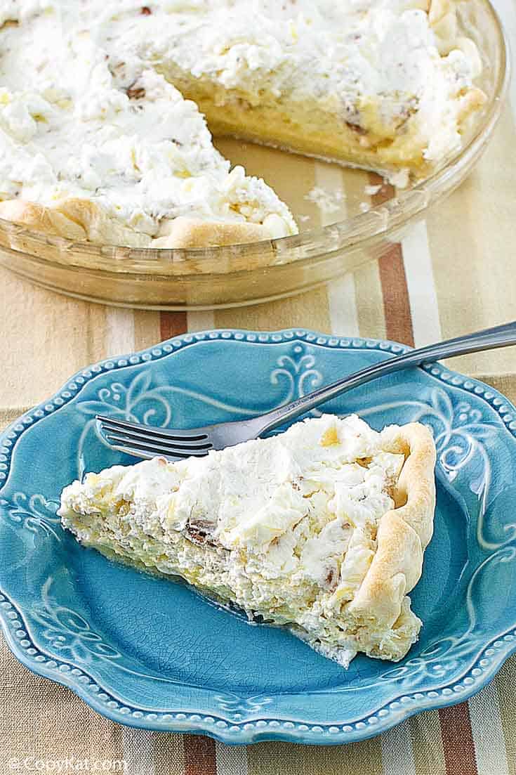 Homemade Furr's Pineapple Millionaire Pie on a blue plate next to the pie