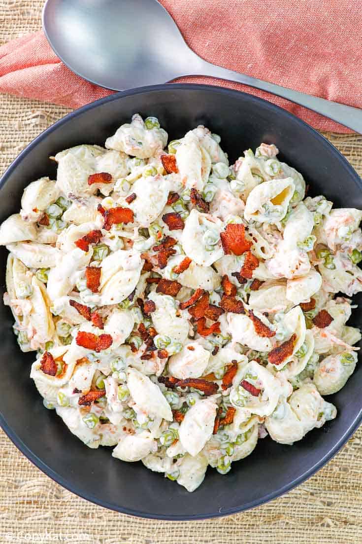 pasta salad with bacon, peas, carrots, and ranch dressing in a black bowl