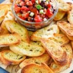 crostini and bowl of tomato topping on a platter