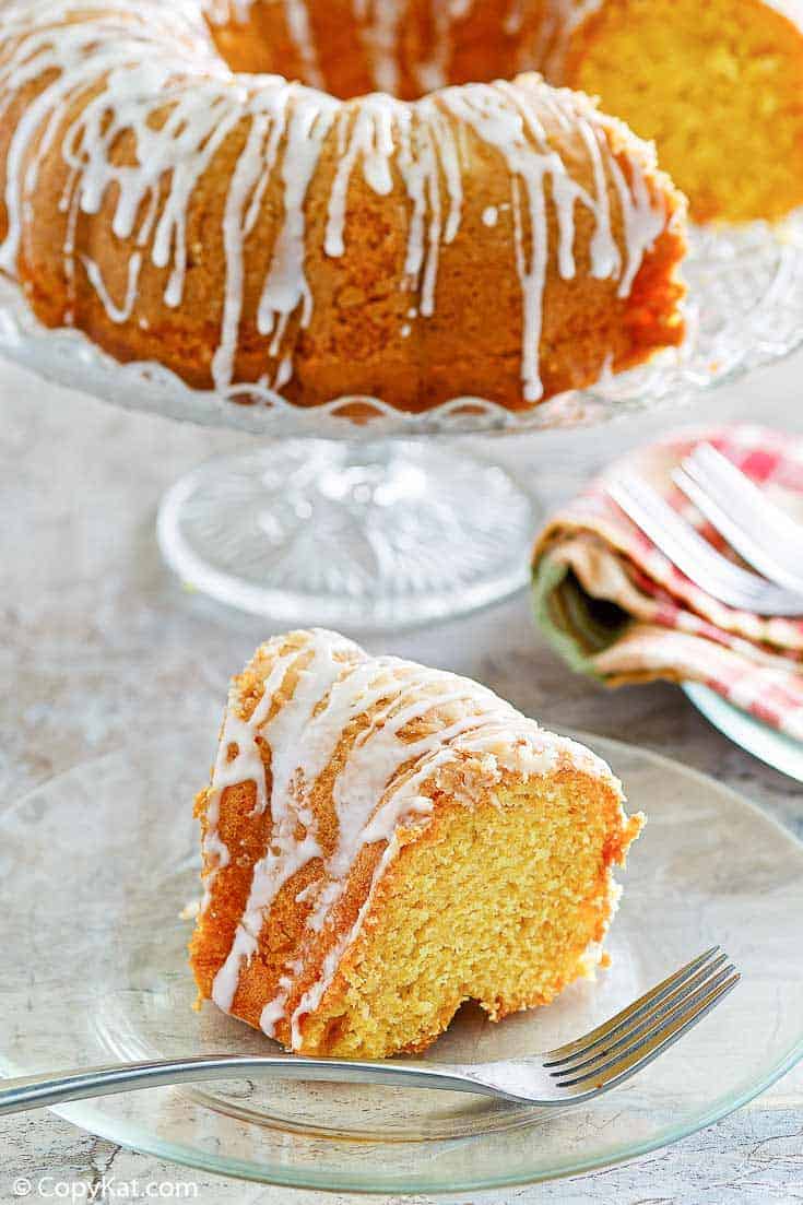 a slice of golden pound cake in front of the cake