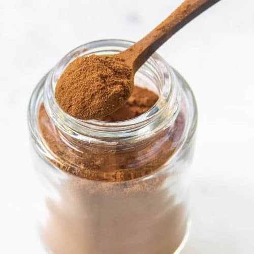homemade pumpkin pie spice mix in a small spoon on top of a spice jar