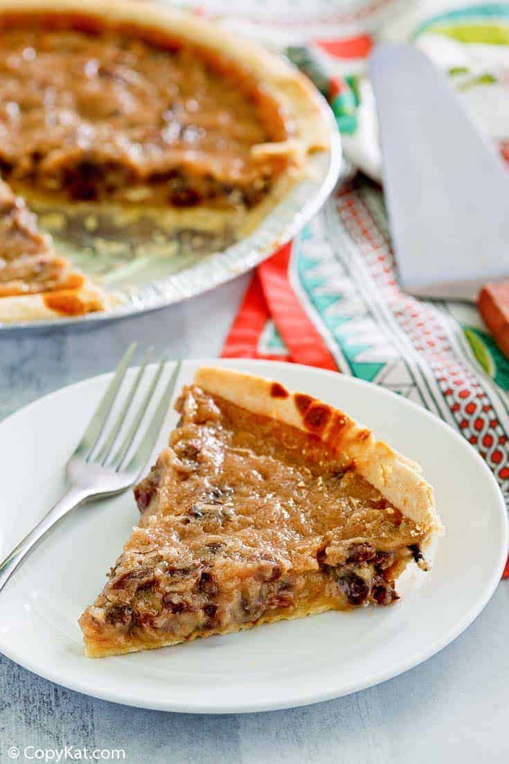 a slice of sour cream raisin pie on a plate next to the pie