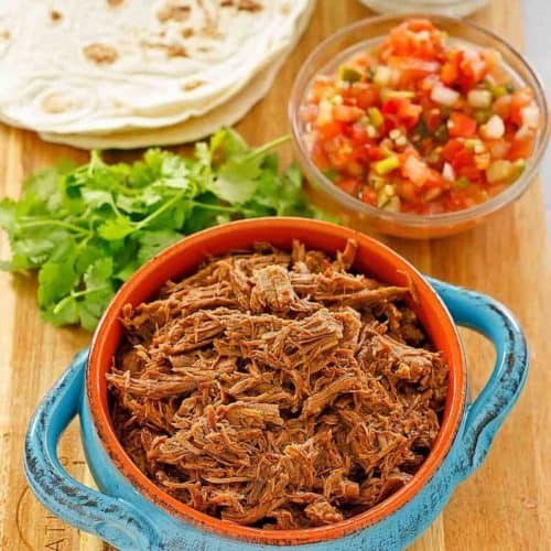 beef barbacoa, cilantro, salsa, tortillas, and sour cream