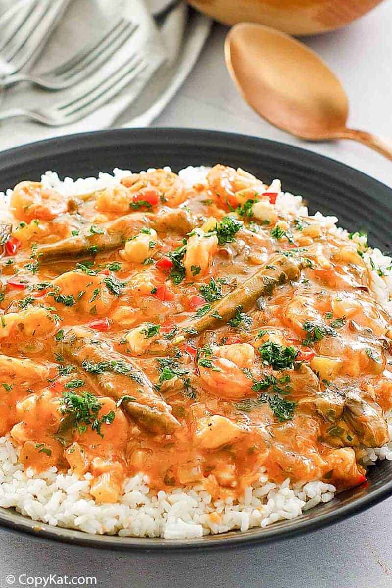seafood gumbo over rice in a black bowl