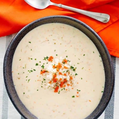 overhead view of a bowl of she crab soup, a napkin, and spoon