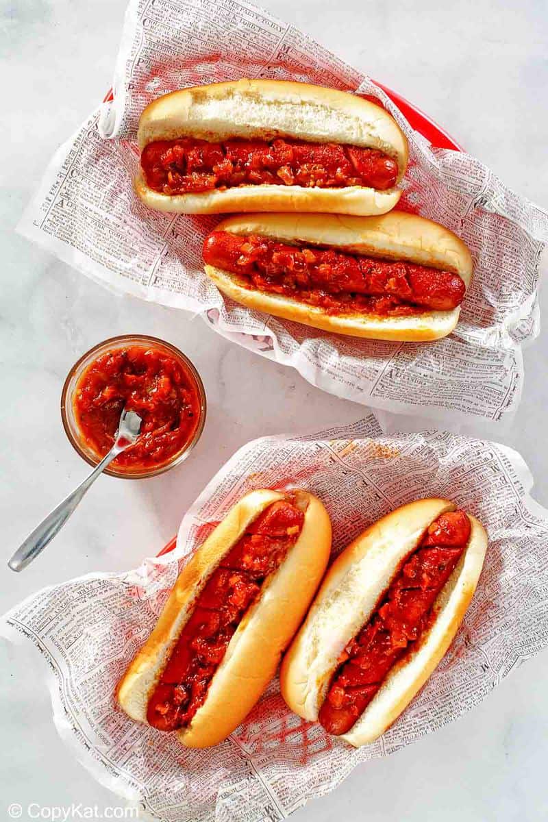 overhead view of four hot dogs topped with barbecue sauce