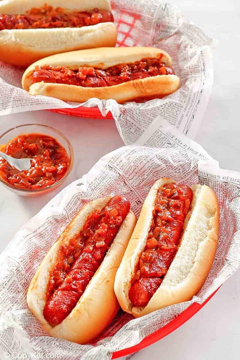two baskets with baked hot dogs topped with barbecue sauce