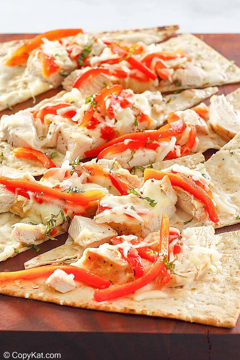 homemade Olive Garden grilled chicken flatbread on a wood board