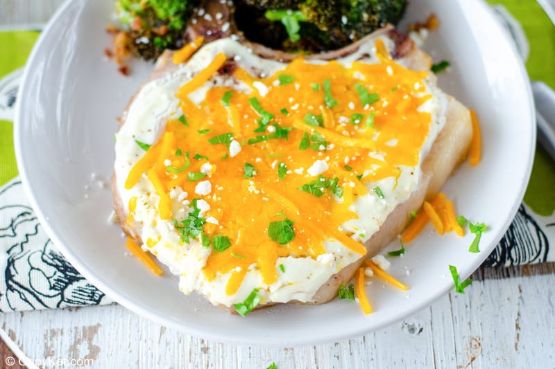 cheesy sour cream baked pork chop and broccoli on a plate
