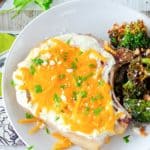 overhead view of cheesy sour cream baked pork chop and broccoli on a plate