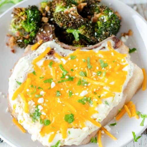 cheesy sour cream baked pork chop and roasted broccoli on a plate