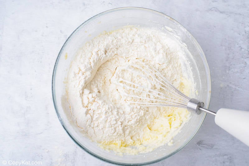 creamed butter and sugar with flour on top in a mixing bowl