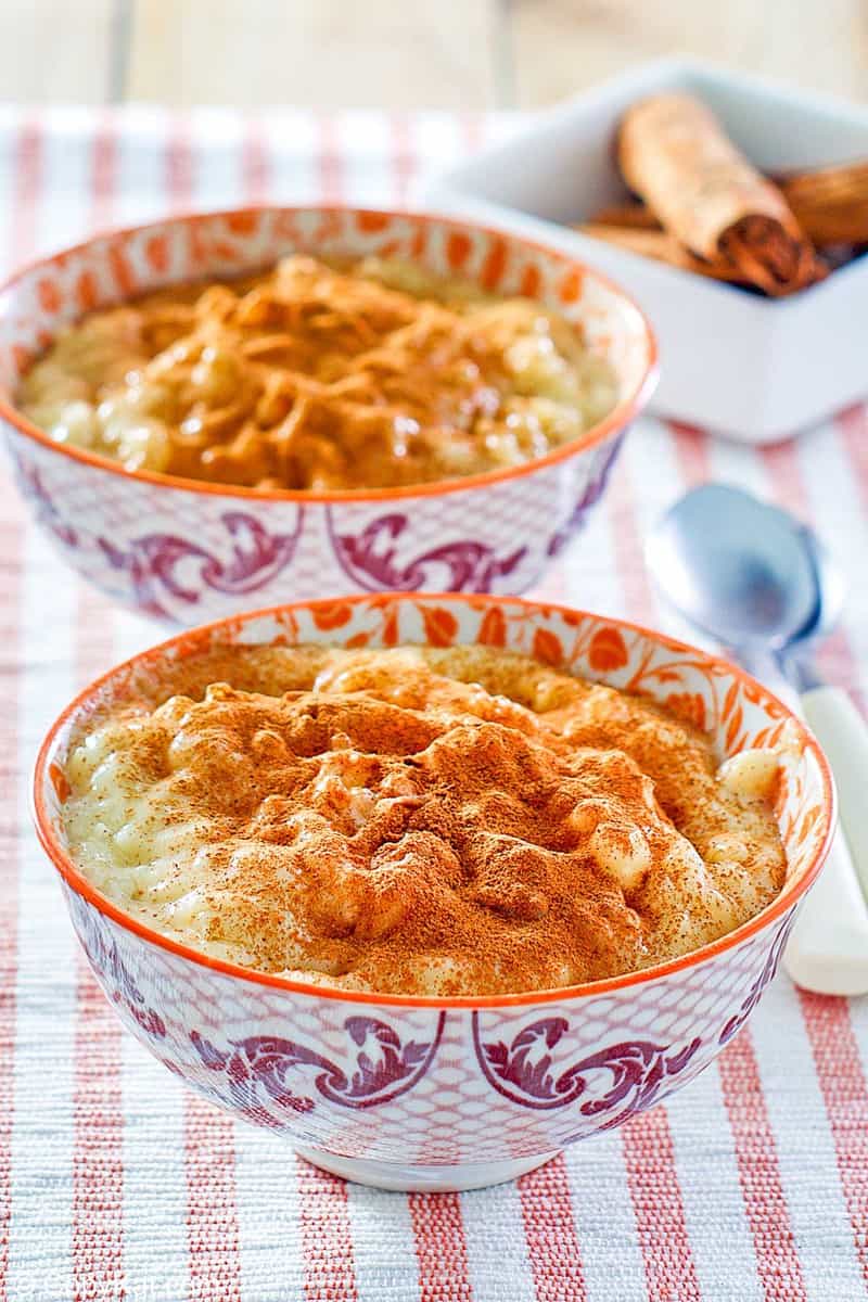 two bowls of homemade Kozy Shack rice pudding and cinnamon sticks