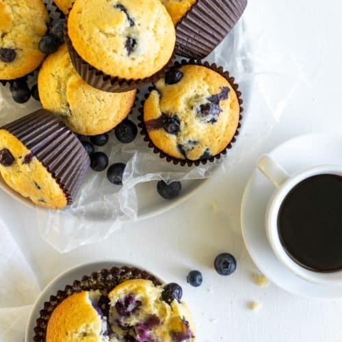 overhead view of blueberry muffins in a basket and on a plate