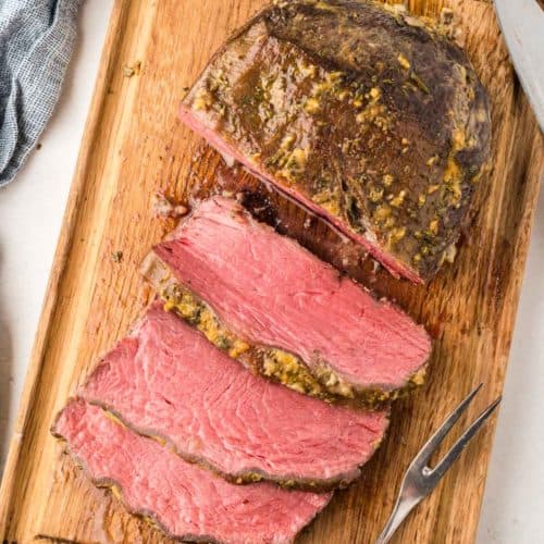 overhead view of cooked and sliced NY strip roast on a cutting board