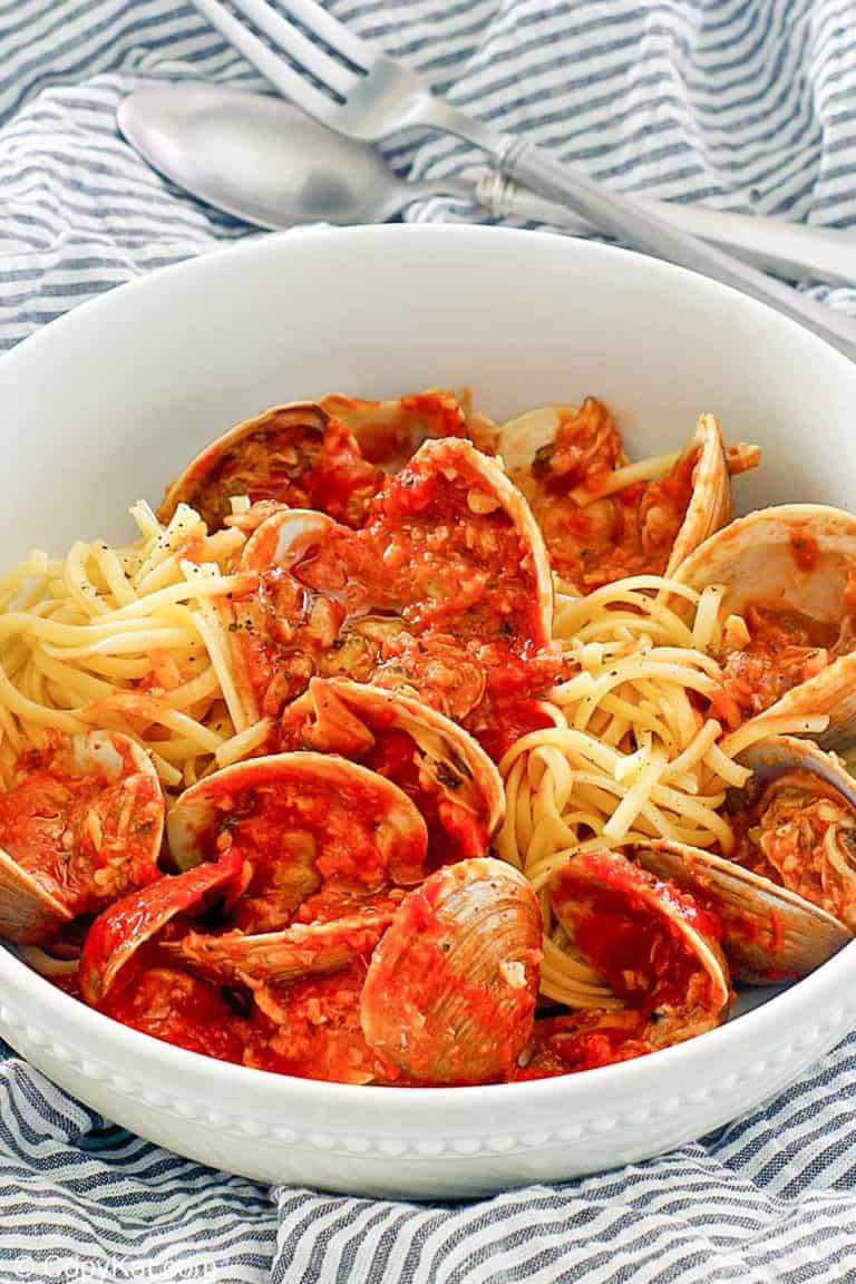 red clam sauce, clams, and pasta in a bowl