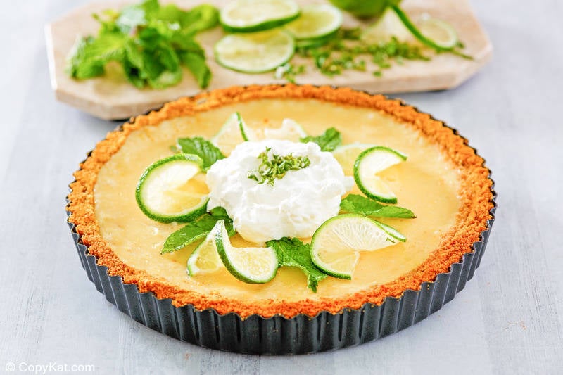homemade Anthony's key lime pie topped with whipped cream, lime slices, and mint leaves
