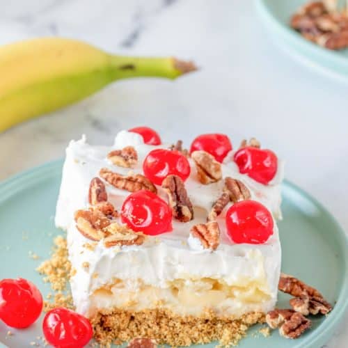 banana split cake slice on a plate next to a banana