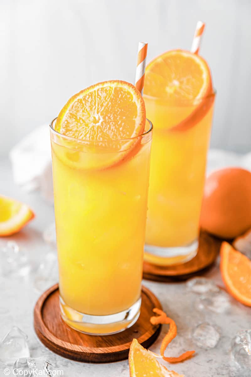 two fuzzy navel drinks on coasters