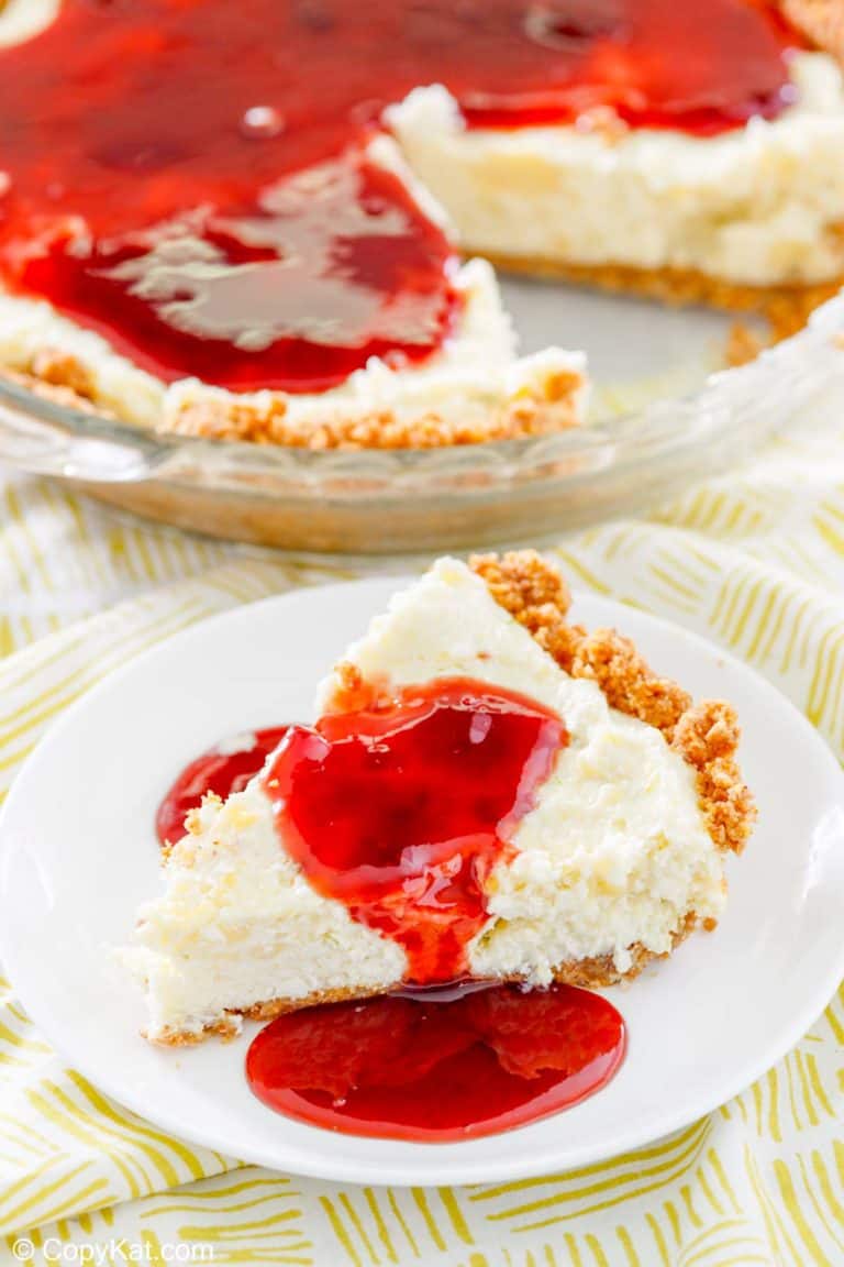 homemade Pappadeaux key lime pie with raspberry sauce in a pie pan and a slice on a plate