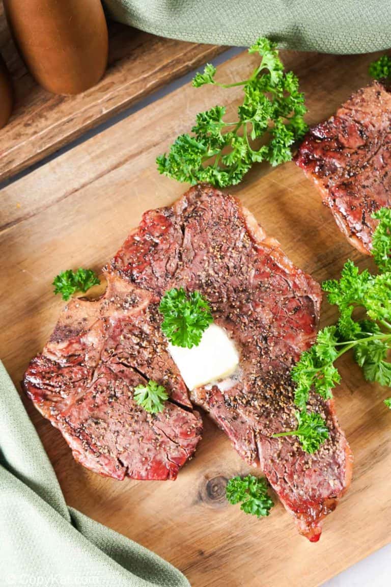 smoked steak and fresh parsley on a wood board