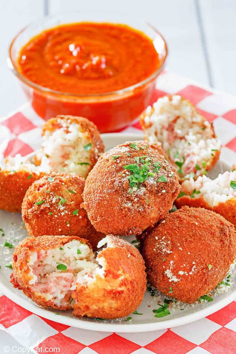Arancini Italian Rice Balls on a plate and a bowl of marinara sauce