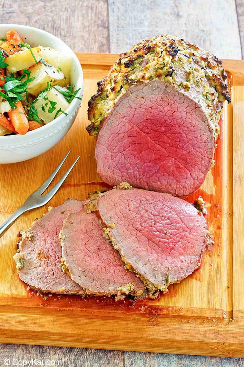 eye of round roast and a bowl of vegetables on a cutting board