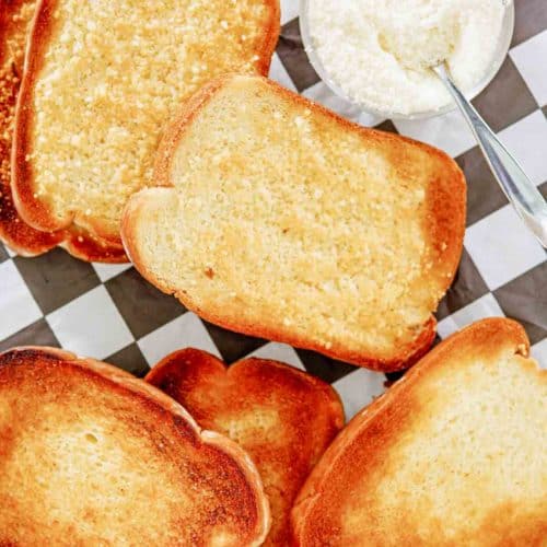 overhead view of texas toast slices and a bowl of parmesan cheese