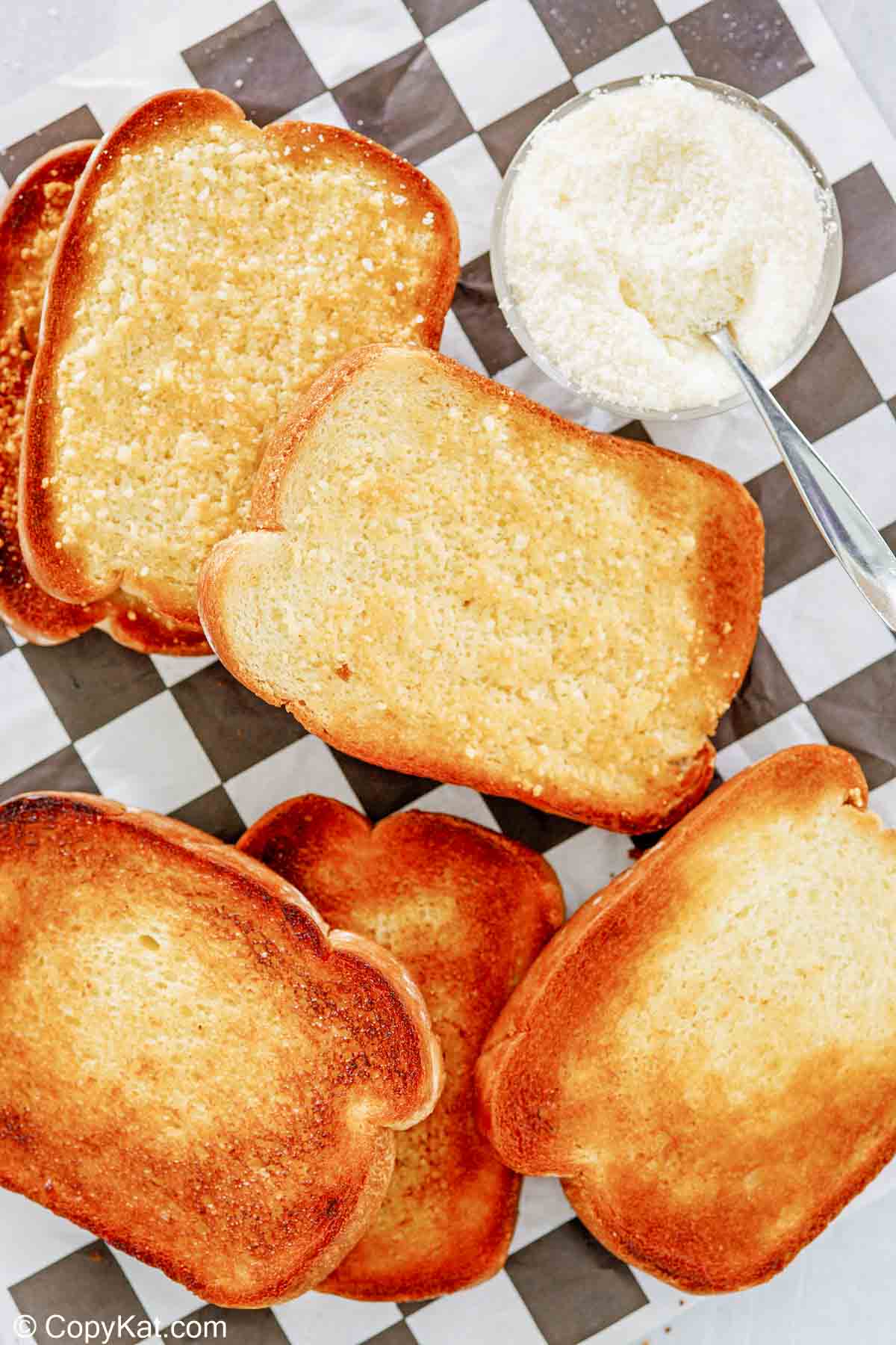 overhead view of texas toast slices and a bowl of parmesan cheese