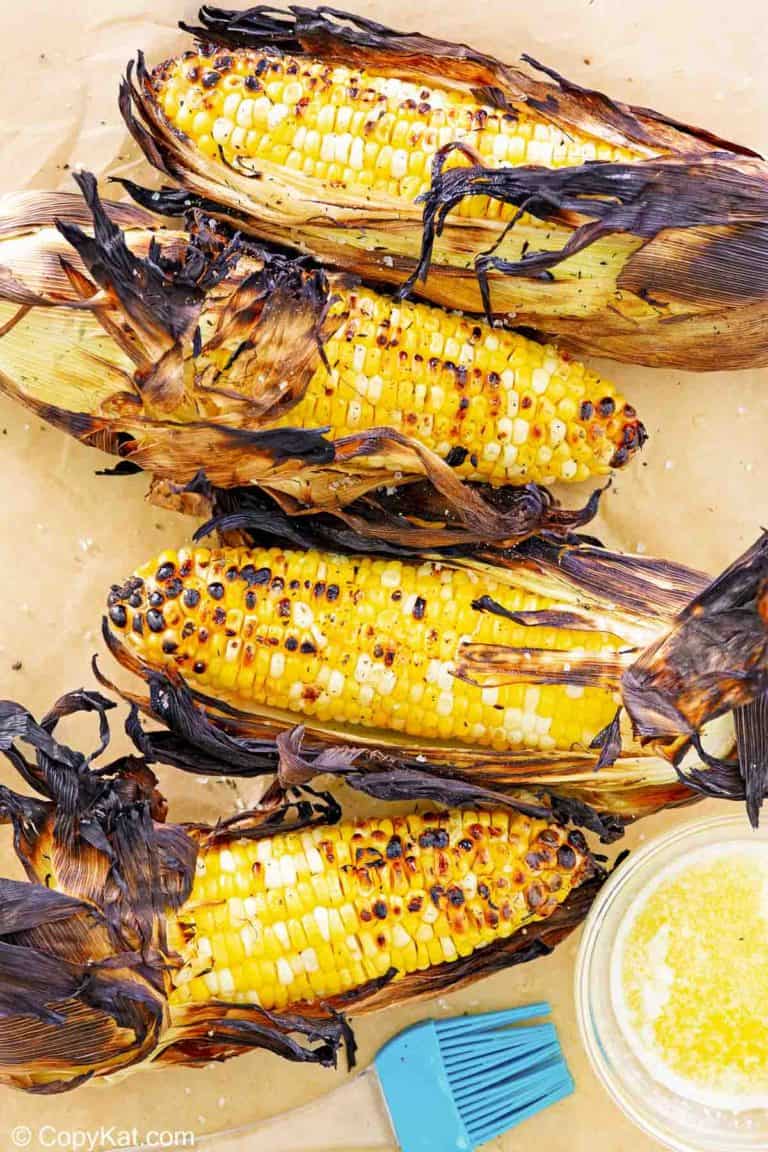 overhead view of grilled corn on the cob on parchment paper.