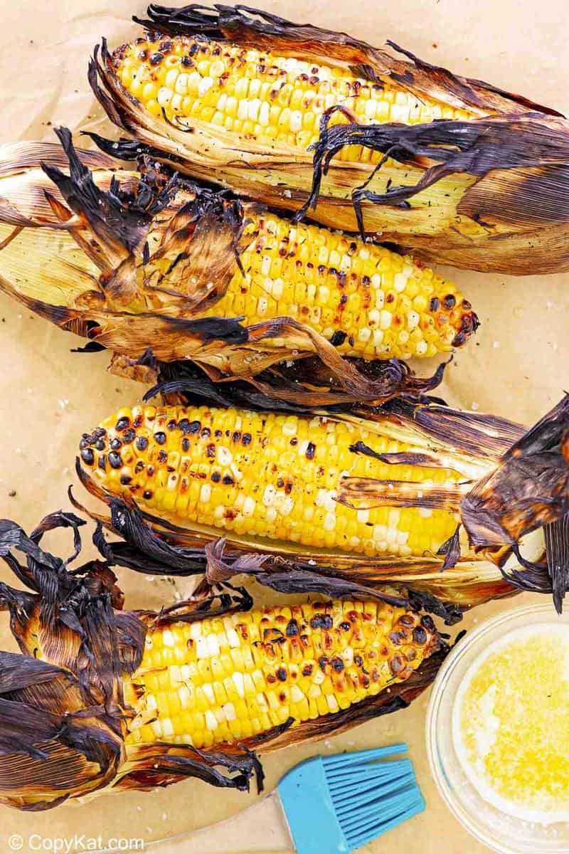 overhead view of grilled corn on the cob on parchment paper.