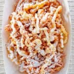 overhead view of funnel cake fries in a paper serving dish