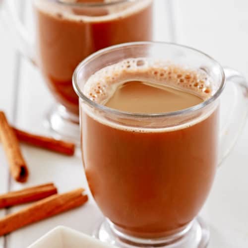 two mugs of Mexican coffee and cinnamon sticks
