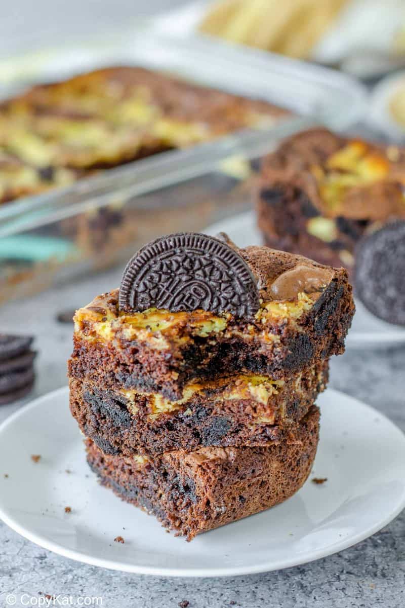 three Oreo brownies on a plate with a bite out of one