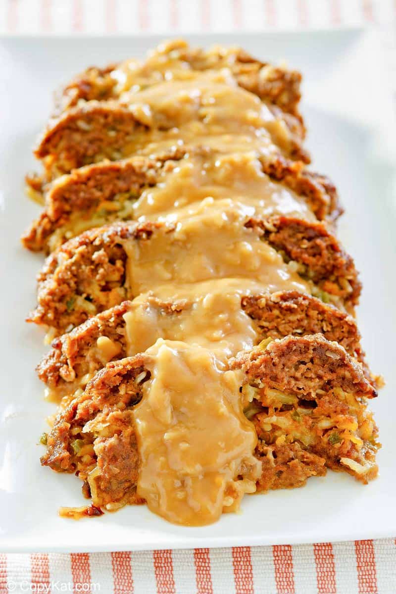 sliced of stuffed meatloaf with gravy on a platter